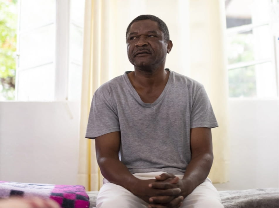 A man sitting on a bed in a shelter